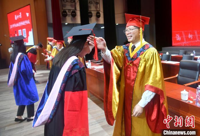 图为校领导为毕业生代表执拨穗礼。 吕明 摄